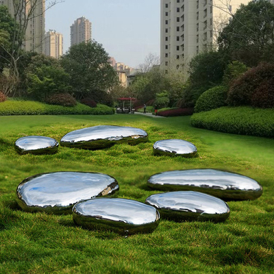 O seixo lustrado alto do jardim de Gnee dá forma à escultura de aço inoxidável para o gramado