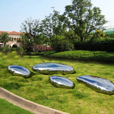 O seixo lustrado alto do jardim de Gnee dá forma à escultura de aço inoxidável para o gramado