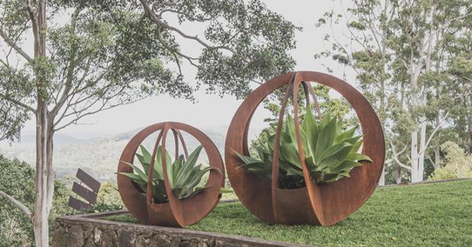 O círculo do projeto simples dá forma a potenciômetros exteriores do plantador do metal com os pires para a decoração do jardim da casa